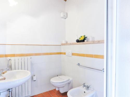 a white bathroom with a toilet and a sink at Apartment Il Melo by Interhome in Grassina