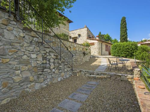 a stone wall with two chairs and a staircase at Apartment Il Melo by Interhome in Grassina