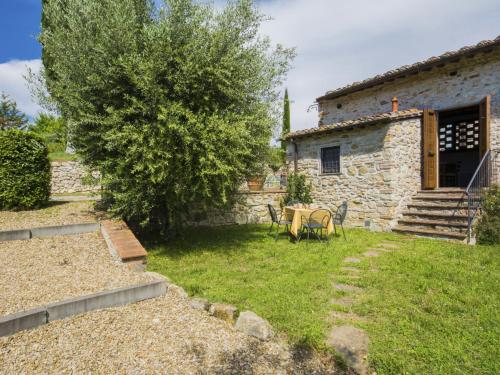 a stone house with a table and chairs in a yard at Apartment Il Melo by Interhome in Grassina