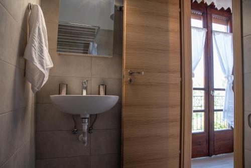 a bathroom with a white sink next to a door at Naia House in Chorefto