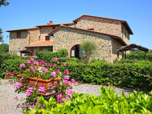 a stone house with flowers in front of it at Apartment Coccinella n-6 by Interhome in Moncioni