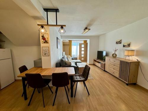 a living room with a dining room table and chairs at Domček pod lesom in Vysoké Tatry