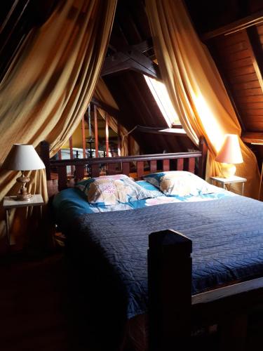- une chambre avec un lit dans une chambre avec des rideaux dans l'établissement Loft atypique hyper centre à 5mn à pied de la plage de l'Écluse 2 à 4 personnes, à Dinard