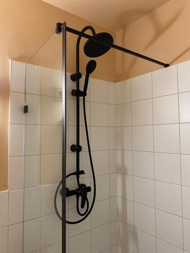 a shower with a shower head in a bathroom at Katalinkert Panzió in Győr