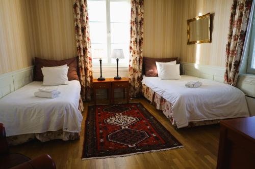 Habitación de hotel con 2 camas y ventana en Brodderud Apartments en Mariestad