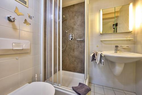 y baño con ducha, lavabo y aseo. en Hotel Antonia en Oberammergau