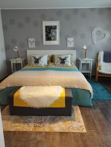 ein Schlafzimmer mit einem großen Bett und zwei Tischen in der Unterkunft Kim`s Cottage in Görwihl