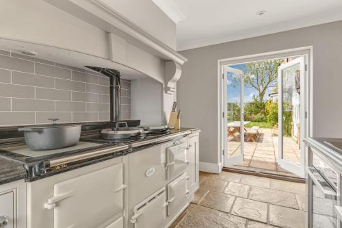 a kitchen with a sink and a door to a patio at Port Hill House in Medbourne