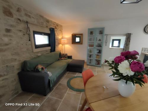 a living room with a couch and a table at Gite à la ferme in Ongles