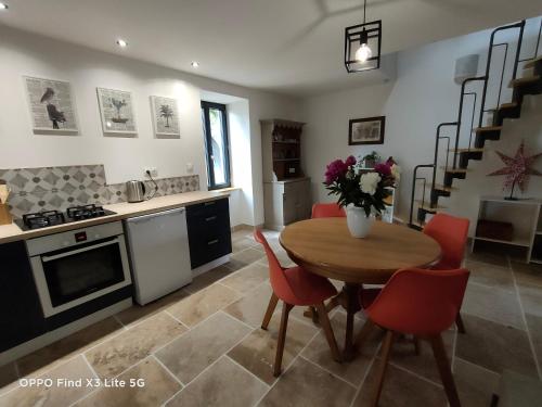 a kitchen and dining room with a table and chairs at Gite à la ferme in Ongles