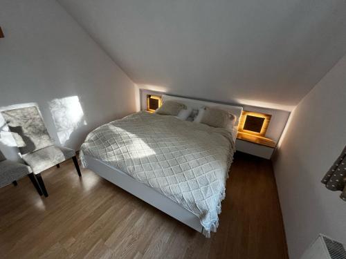 a small bedroom with a bed and a chair at Domček pod lesom in Vysoké Tatry
