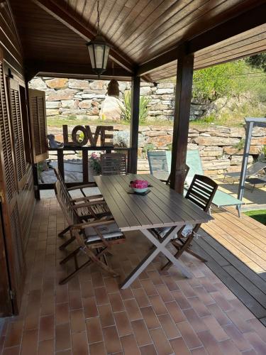 - une table en bois et 2 chaises sur une terrasse couverte dans l'établissement Maison de vacances, à Aléria