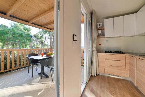 a kitchen and dining room with a balcony at Kamp Rožac in Trogir