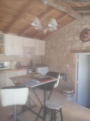 une cuisine avec une table et quelques chaises dans l'établissement Castel Mazars gîte, à Castelnau-de-Montmiral