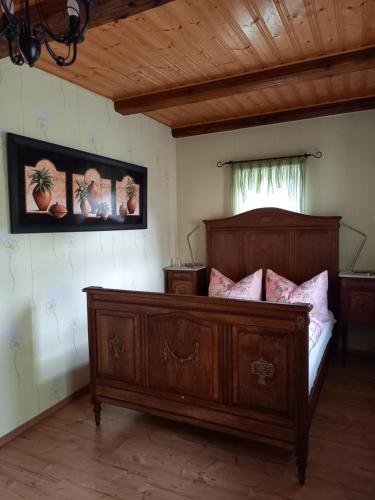 a bedroom with a wooden bed with pink pillows at Pension Spreeeck in Habrachćicy