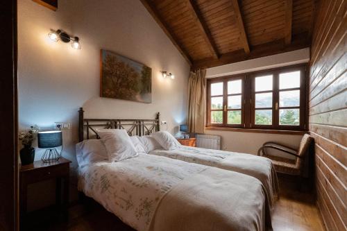 ein Schlafzimmer mit einem großen Bett in einem Zimmer mit Fenstern in der Unterkunft Apartamentos Rurales San Feliz in Pola de Lena