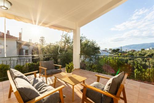 a patio with chairs and a table on a balcony at Avia's Seaside Hideaway with Lush Garden in Avia
