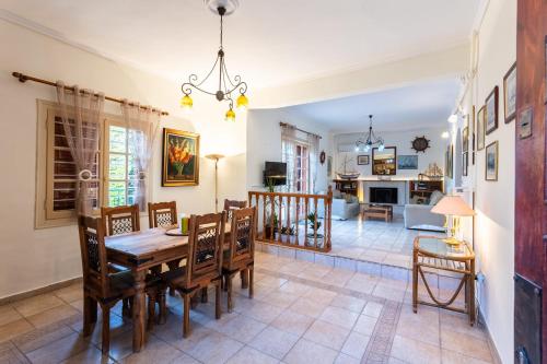 a dining room and living room with a table and chairs at Avia's Seaside Hideaway with Lush Garden in Avia