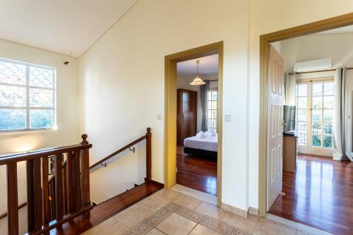 a room with a hallway with a bed and a staircase at Avia's Seaside Hideaway with Lush Garden in Avia