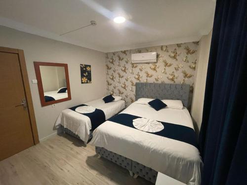een hotelkamer met 2 bedden en een spiegel bij The Temple Butik Otel in Kuşadası