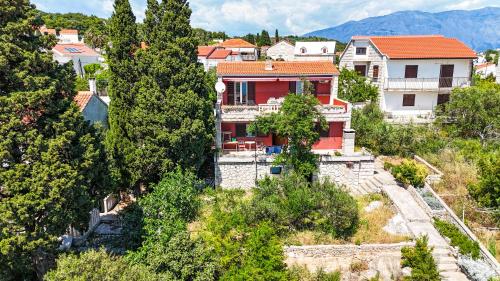 a house on a hill with trees and houses at Apartman Damir in Sumartin
