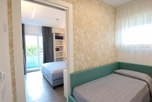 um quarto com uma cama e um espelho em Hotel Paris em Lignano Sabbiadoro