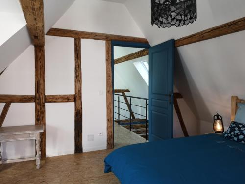 a bedroom with a blue bed and wooden beams at Au 19 de Lina in Hoerdt