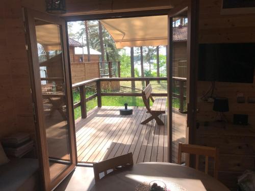 a screened in porch with a view of a deck at Domek z widokiem jeziora in Borsk