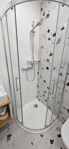 a shower with a glass door in a bathroom at Apartments & Rooms KARLA in Dramalj