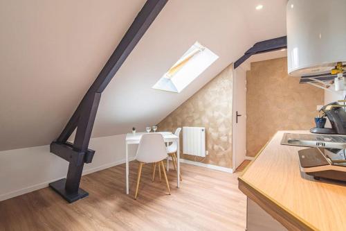 - une cuisine et une salle à manger mansardée avec une table dans l'établissement L'Azur doré, studio pour 2 voyageurs, à Isles-sur-Suippe