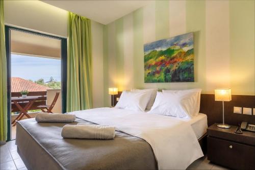 a bedroom with a large white bed with a balcony at Agrilia Hotel Adults Only in Laganas