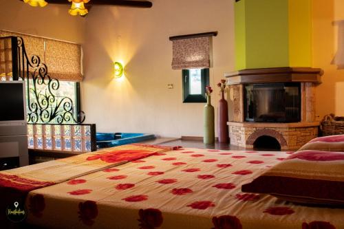 a bedroom with a large bed and a fireplace at Luxury House with huge garden - Near "Mavra Volia" Beach in Emporeiós