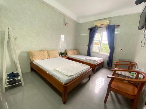 a bedroom with two beds and a window at HAI DANG HOTEL in Xóm Ðé
