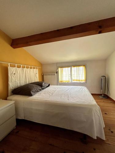 une chambre avec un grand lit blanc avec une fenêtre dans l'établissement Splendide villa avec piscine chauffée, à Sallèles-dʼAude