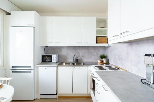a white kitchen with white cabinets and a sink at Hygge Home in Rovaniemi, free parking and Netflix in Rovaniemi