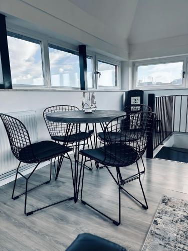 a table and chairs in a room with windows at Wohnen im Turm Genialer Schlossblick in Steinfurt