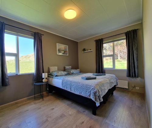 1 dormitorio con 1 cama y 2 ventanas en Helgafell Guesthouse en Stykkishólmur