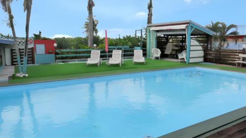 una piscina con sillas y un cenador en Maison de 3 chambres avec piscine partagee jardin clos et wifi a Sainte Anne a 3 km de la plage, en Sainte-Anne