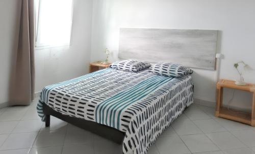 a bedroom with a bed with two pillows on it at Maison de 3 chambres avec piscine partagee jardin clos et wifi a Sainte Anne a 3 km de la plage in Sainte-Anne