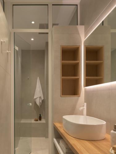 a bathroom with a white sink and a shower at Loft 26 in Ierapetra