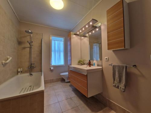 y baño con lavabo, bañera y aseo. en Helgafell Guesthouse en Stykkishólmur