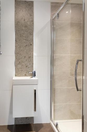 a shower with a glass door in a bathroom at The Luxury House in Swanland