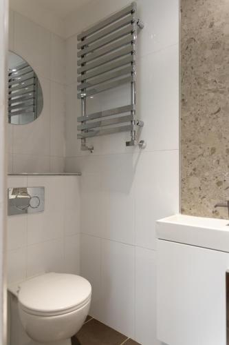 a white bathroom with a toilet and a sink at The Luxury House in Swanland