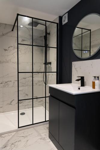 a bathroom with a shower with a sink and a mirror at The Luxury House in Swanland