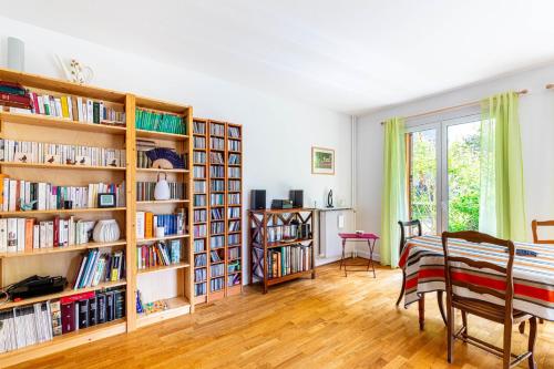 une chambre avec des étagères en bois remplies de livres dans l'établissement GuestReady - Stylish haven near La Seine Musicale, à Meudon