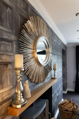 a mirror on a wall in a living room at The Luxury House in Swanland