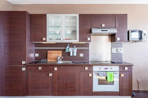 une cuisine avec des armoires en bois et un évier dans l'établissement GuestReady - Modern chic with a view, à Courbevoie