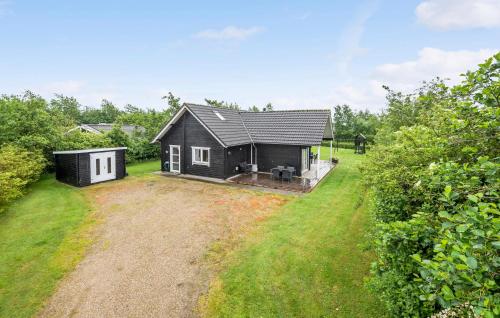 a black and white house with a yard at Three-Bedroom Holiday Home In Hemmet in Hemmet