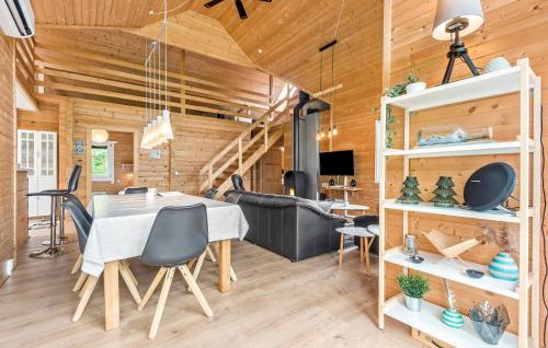 a dining room with a table and chairs and wooden walls at Three-Bedroom Holiday Home In Hemmet in Hemmet