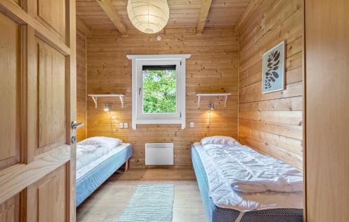 - une chambre avec 2 lits dans un mur en bois dans l'établissement Lovely Home In Hemmet With Wifi, à Hemmet